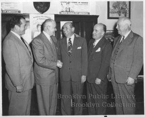 "Flatbush Boys Club elects new officers. Left to right: Arthur R. Gaines, corresponding secretary; Senator Samuel L. Greenberg, retiring president congratulates Arthur C. Ebinger, the new president; Dr. Talbot H. LeBlanc, first president, and Ripley L. Sadler, recording secretary ..." From the 